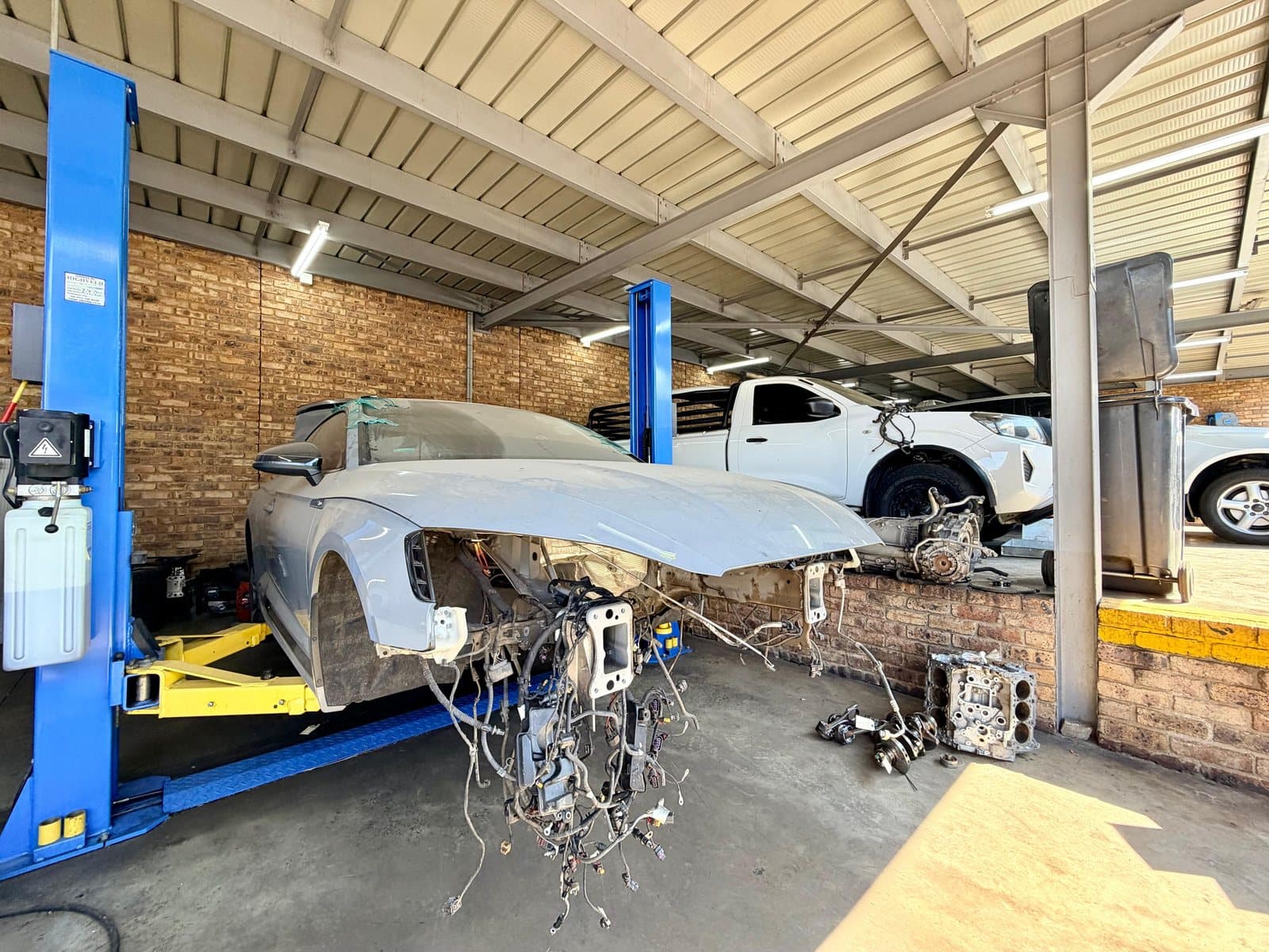 A vehicle with the front removed for engine work in a Vision Motors service bay, Pretoria