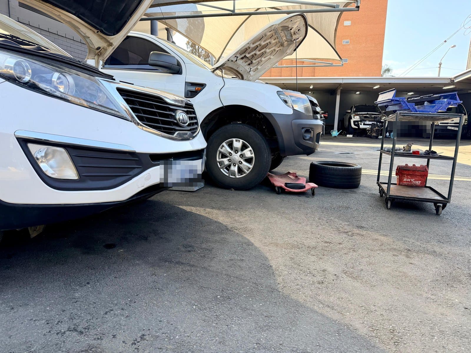 Two vehicles up for repair in the outdoor service bay at Vision Motors, Wonderboom South, Pretoria