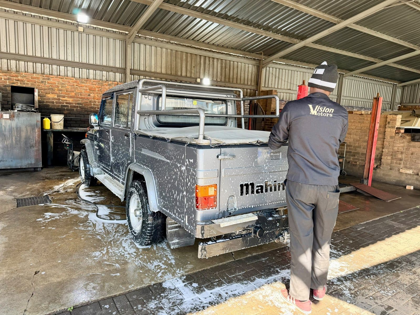 A Vision Motors technician in a branded jacket preparing a customer vehicle in Wonderboom South, Pretoria