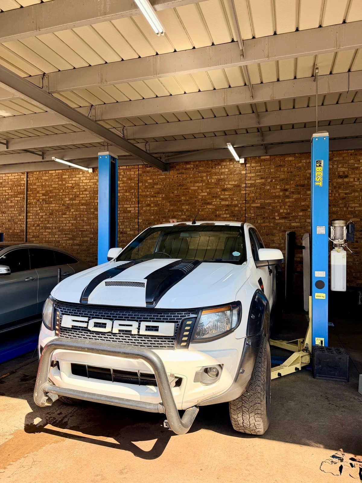 A vehicle raised on a two-post lift in the Vision Motors workshop, Wonderboom South, Pretoria