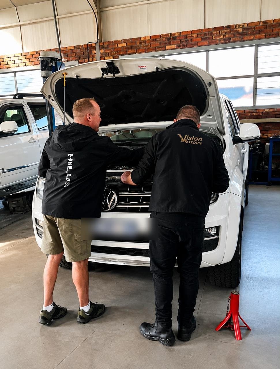 Two Vision Motors technicians diagnosing a vehicle together in the workshop, Wonderboom South, Pretoria